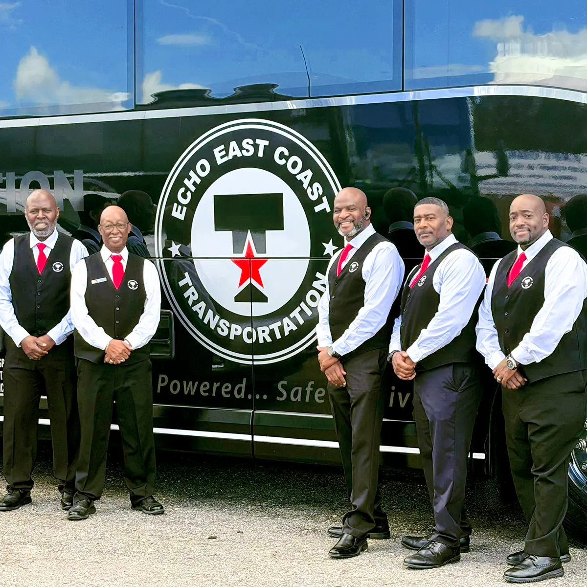 Five chauffeurs in uniform standing in front of an ECHO East Coast motorcoach